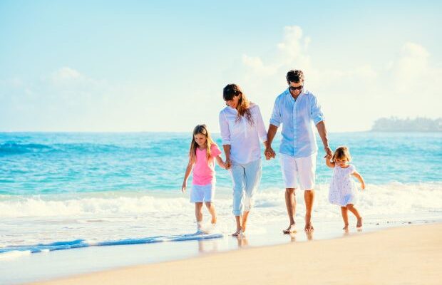 Happy family walking on the beach
