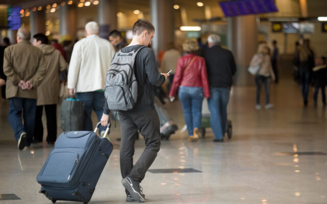 Back,View,Of,Young,Handsome,Traveler,Walking,In,Modern,Airport